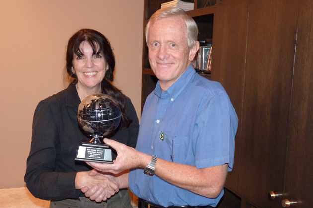 TCC President Pamela Barrus presents Rowland Burley with his globe for having traveled to all of the countries on the TCC list. He was honored, with five others, at the March 2010 TCC luncheon in Anaheim, California, but could not attend because he lives in Hong Kong. He and the others completed their lists when they visited Wake Island on Dec. 9, 2009. Globes have already been presented to the other five members.
