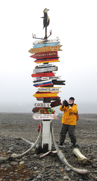 Frank Rainer is pictured with directional signs at the Uruguayan Artigas Station on King George Island.