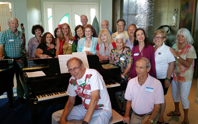 A lively group attended the 2014 Southeast Florida holiday party in December. Bob Petrik , our Host, in foreground played on his piano sing a long Holiday Carols For group that attended TCC S.E. Fla. Holiday Party. Second from right is Cecelia Rokuset, the hostess.  Everybody also brought a wrapped travel souvenir for Gift exchange!
